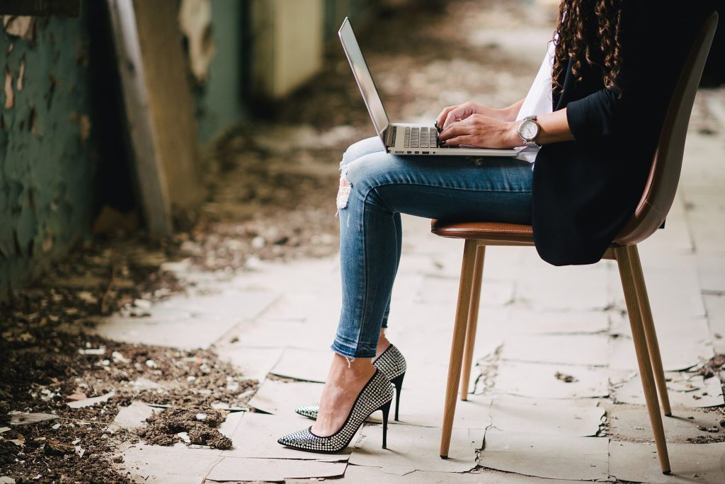Deep Work in a Distracted Age Is a Design Problem Woman working on laptop while sitting in abandoned building with damaged walls and floor in an urban setting during daytime